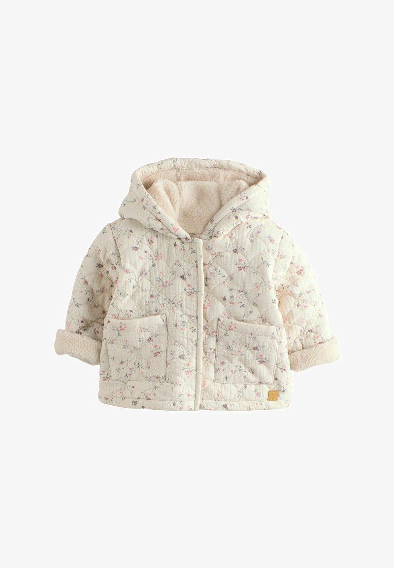 Veste matelassée crème à capuche avec imprimé floral, deux poches avant, et doublure douce en polaire visible aux poignets et à la capuche.