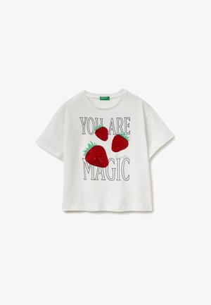 Biały t-shirt z krótkim rękawem z trzema czerwonymi truskawkami z cekinów i napisem „YOU ARE MAGIC” czarnymi literami na przodzie.