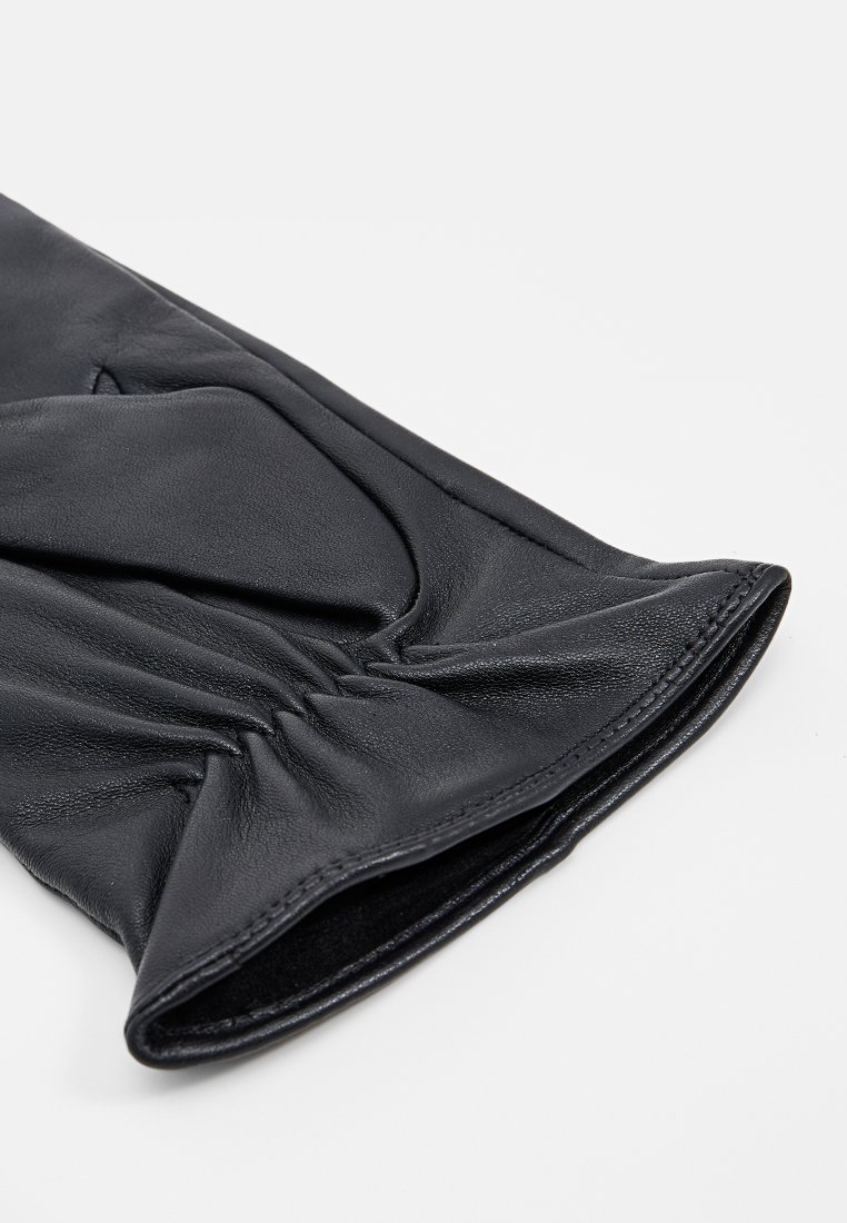 Schwarzer Lederhandschuh mit glatter Textur, ausgestattet mit gerafften Details am Handgelenk und einem leicht ausgestellten Öffnungsbereich.