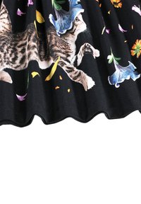 Ilustracija tabby mačke s plavim metuljem na glavi, okružena šarenim cvjetnim laticama na crnoj tkanini.