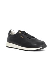 Black leather sneaker with white sole, black laces, and small gold "Dune" logo on side, shown at slight angle on white background.