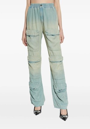 Pantaloni cargo blu slavati e larghi con molte tasche a patta, indossati con décolleté nere con punta a punta e fibbie argento.