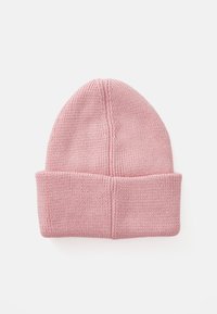 Bonnet en tricot rose avec un revers roulé, présentant un tissu texturé et extensible ainsi que des détails de couture subtils au sommet.