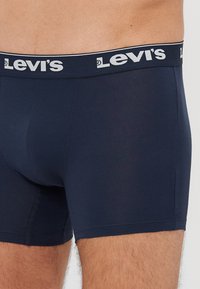 Sötétkék pamut boxer alsónadrág puha elasztikus Levi's derékpánttal, fehér logós felirattal. Simaság és testhezálló fazon.