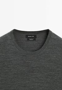 Dark gray merino wool crew neck sweater with ribbed collar and black tag reading "Massimo Dutti" and fabric information.