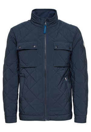 Granatowa pikowana kurtka z kołnierzem stójkowym, dwoma kieszeniami na piersi z zapięciem na zatrzask, zamkiem z przodu oraz kontrastowym wykończeniem po lewej stronie.