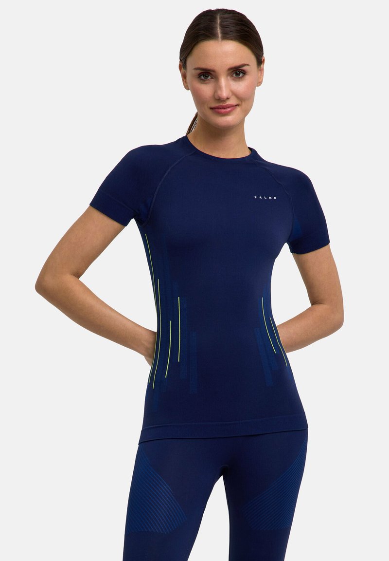 Maglietta sportiva a compressione navy con maniche corte. Presenta strisce verticali verdi a contrasto. Texture liscia, design aderente per il massimo comfort.