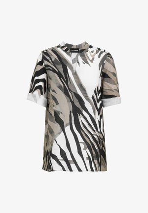 Short-sleeve blouse with rolled cuffs and abstract zebra stripes in black, white, and beige tones, featuring a split V-neck collar.