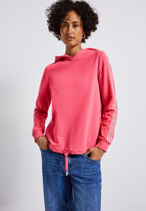 Rosa Kapuzenpullover mit Kordelzug, gerippten Bündchen und seitlichen Streifen. Kombiniert mit lockeren blauen Jeans. Weiche Textur, lässiges Design.