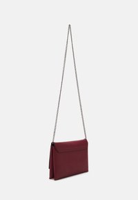 Sacoche bordeaux au design plat, avec une bandoulière en chaîne et une texture lisse. Présente un rabat repliable avec des détails de couture, sans matériel visible.
