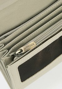 Portafoglio in pelle beige con più scomparti, interno in tessuto testurizzato e una zip metallica con il marchio "WITTCHEN".