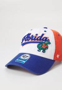 Hvit, oransje og blå caps med "Florida" og en grønn alligatorlogo. Har justerbar bakdel og buet skjerm.