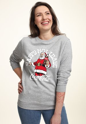 Šedá mikina s grafikou Santa a textem "Veselé svátky" a brandingem Coca-Coly. Kulatý výstřih a dlouhé rukávy.