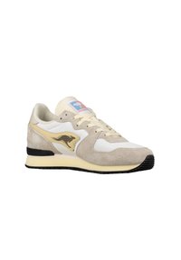 Sneaker beige e bianco con una tomaia in suede, pannelli in mesh, dettagli dorati e suola in gomma nera. Presenta chiusura con lacci e dettagli del logo.