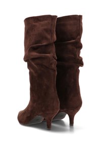 Botas de ante marrón hasta media pantorrilla con diseño holgado, punta en forma de lágrima y tacón de 3 pulgadas. Textura suave con costuras mínimas y acabado liso.