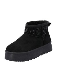 Botas negras de tobillo hechas de ante con una suela plana y texturizada. En los laterales cuentan con tachuelas decorativas negras para un detalle adicional.