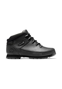 Botte de randonnée Timberland noire mi-montante avec col rembourré, œillets métalliques et semelle épaisse crantée, présentée en profil latéral sur fond blanc.