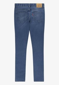 Jeans skinny de mezclilla azul con cintura alta, que cuentan con dos bolsillos traseros y un parche de cuero de la marca en la cinturilla. Diseño clásico de cinco bolsillos.