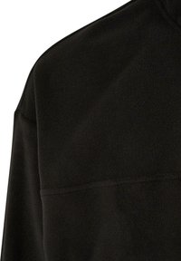 Svart fleece-pullover med høy krage og lange ermer. Myk tekstur uten synlige mønstre eller hardware-detaljer.