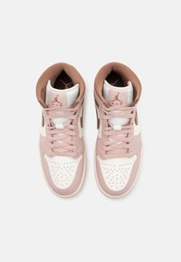 Paire de baskets montantes Air Jordan roses et blanches avec des accents et lacets marron, vues de dessus sur un fond uni.