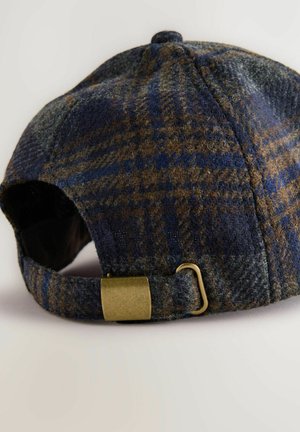 Gorra de lana a cuadros marrón y azul con forma redondeada, que presenta un regulador de latón y una tela texturizada en la parte posterior.