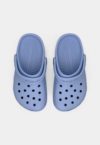 Ζευγάρι ανοιχτόχρωμων μπλε Crocs με αερισ holes και ρυθμιζόμενους ιμάντες φτέρνας, απεικονίζονται από ψηλά σε λευκό φόντο.