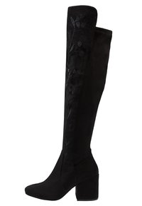 Botas negras por encima de la rodilla de ante con bordado floral en la caña, con tacón bloque para mayor estabilidad y un diseño elegante.