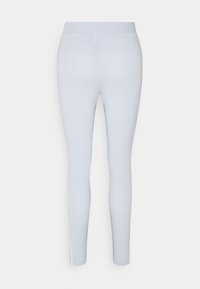 Schmale Leggings in Hellblau mit glatter Textur und breitem elastischem Bund. Keine sichtbaren Drucke oder Verzierungen.
