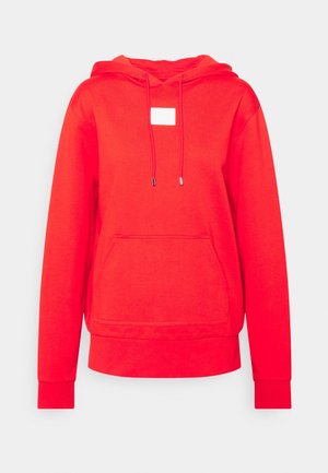 Sweat à capuche rouge à manches longues avec poche kangourou frontale, capuche avec cordon et petite étiquette blanche rectangulaire au centre de la poitrine.