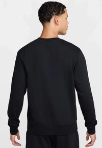 Felpa nera, materiale in cotone, design a girocollo, maniche lunghe, polsini e orlo a costine, texture liscia, stile minimalista, senza decorazioni.