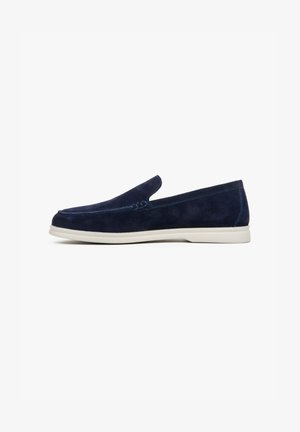 Navy blue suede slip-on shoes with a smooth finish and white rubber sole. Features a decorative stitch on the upper and a minimalist design.