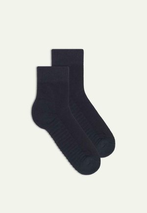 Dark navy skarpetki z zaokrąglonym przodem, wykonane z miękkiego materiału z żeberkowymi mankietami, gładką teksturą oraz wzmacnianymi palcami i piętami dla większej trwałości.