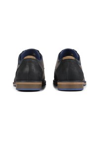 Zwarte leren schoenen met een gestructureerd lichaam, bruine accenten bij de hiel en blauwe details op de zool. Rond neus en een gevoerde kraag design.