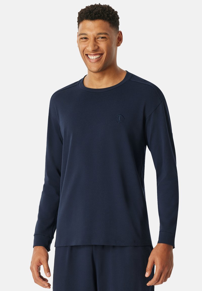 Navyblaues Langarmshirt aus weichem Stoff, mit rundem Hals, gesticktem Logo auf der Brust und gerippten Bündchen. Regelmäßige Passform.