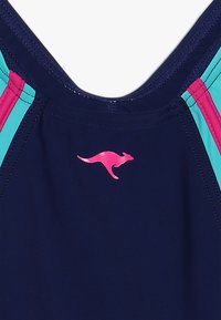 Maillot de bain de marine avec des rayures d'accent turquoise et rose. Présente un logo de kangourou rose sur la poitrine. Matériau lisse et extensible.