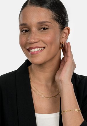 Gold jewelry set featuring two layered necklaces and a bracelet. One necklace has varied links with accents; earrings are hoop style.