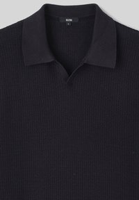 Pull polo en tricot bleu marine avec une surface texturée, col court et design en V. L'étiquette indique la taille "L" et la marque "BZW."