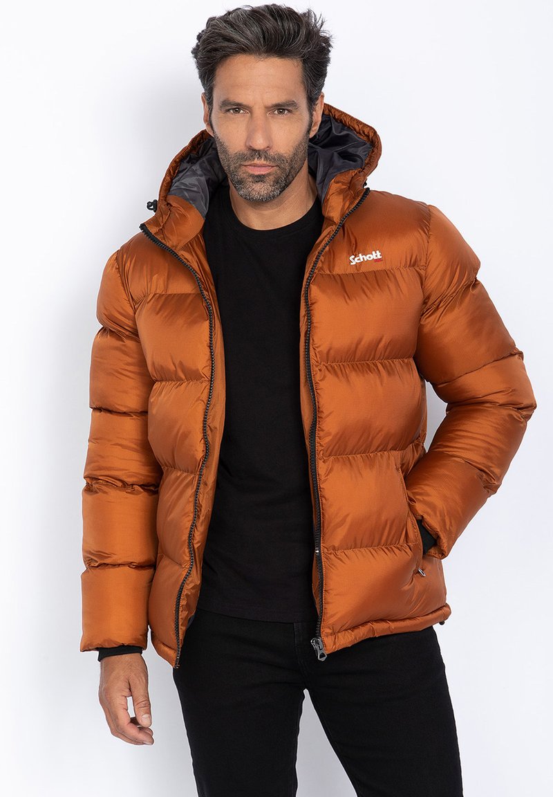 Giacca outdoor arancione imbottita con cappuccio, caratterizzata da un design trapuntato, zip frontale e una fodera interna nera. Logo del marchio sul petto.