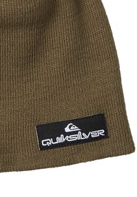 Brązowa wełniana czapka z dzianiny z czarną metką z białym logo „Quiksilver”. Design jest prosty, o gładkiej teksturze i dopasowanym kształcie.