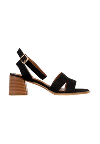 Sandale noire en daim à bout ouvert avec talon bloc en bois, deux brides avant et bride de cheville réglable avec boucle dorée.