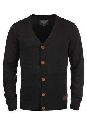Zwarte cardigan met een V-hals, vijf bruine knopen, geribbelde manchetten en een klein leren accentpatch aan de zoom. Zacht materiaal, slim fit ontwerp.