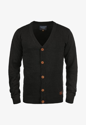 Čierny cardigan s V-výstrihom, piatimi hnedými gombíkmi, rebrovanými manžetami a malou koženou nášivkou na leme. Mäkkučký materiál, priliehavý strih.