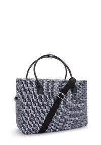 Patterned tote bag in navy and white fabric, featuring black leather handles and a detachable strap, rectangular shape, and zip closure.