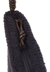 Pochette noire texturée avec un extérieur duveteux et une fermeture éclair. Dispose d'un cordon noué pour la fermeture. Le matériau semble doux et durable.