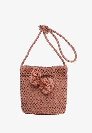 Woven pink shoulder bag with braided strap, featuring two decorative fabric pom-poms on the front closure.