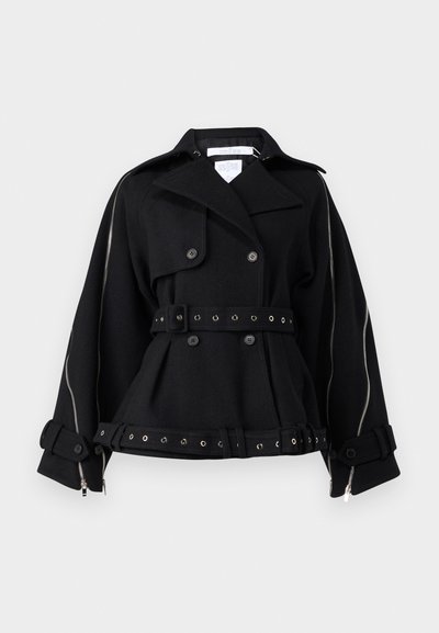 Black wool coat with a double-breasted design, belted waist, and silver hardware accents. Features large buttons and zipper details on sleeves.