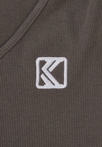 Brun ribbet stoff med dyp V-hals. Har en hvit brodert logo innenfor en kvadratisk ramme på venstre side.
