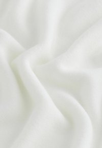 Textuurwit stof met een zachte, gladde uitstraling, die zachte plooien en een lichte, gelijkmatige weefpatroon laat zien. Ideaal voor verschillende textieltoepassingen.