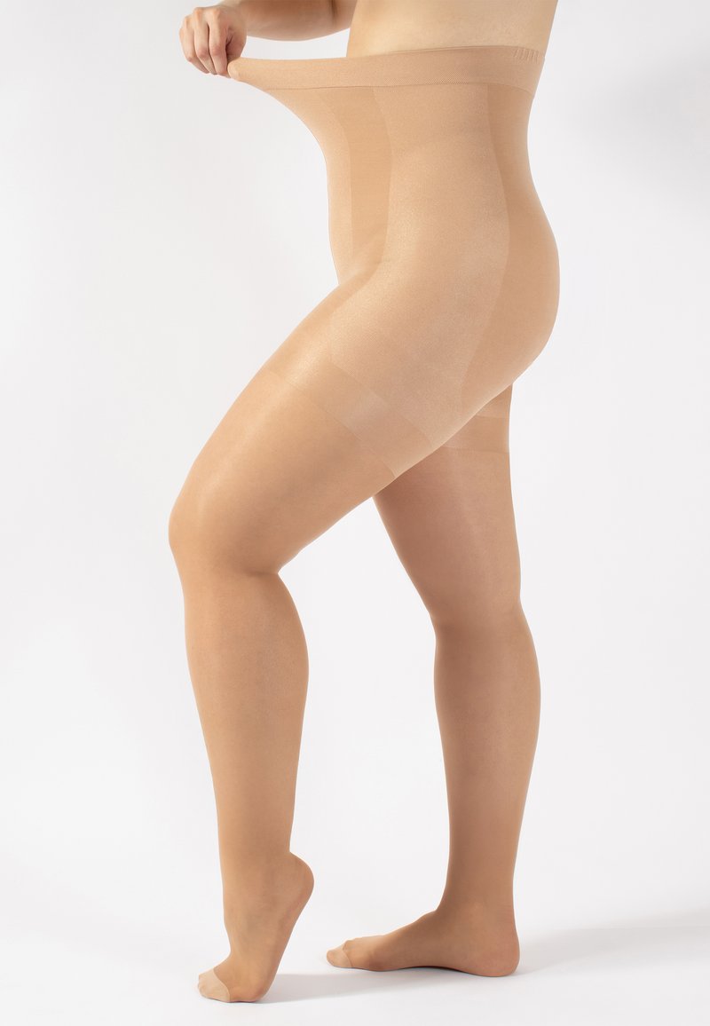 Medias de tul beige siendo estiradas, con una textura suave y un acabado semitranslúcido, además de un diseño de cintura alta.