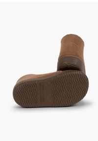 Botas de tobillo de ante marrón con una suela de goma texturizada, que presentan una puntera redondeada y costuras contrastantes a lo largo de las costuras.